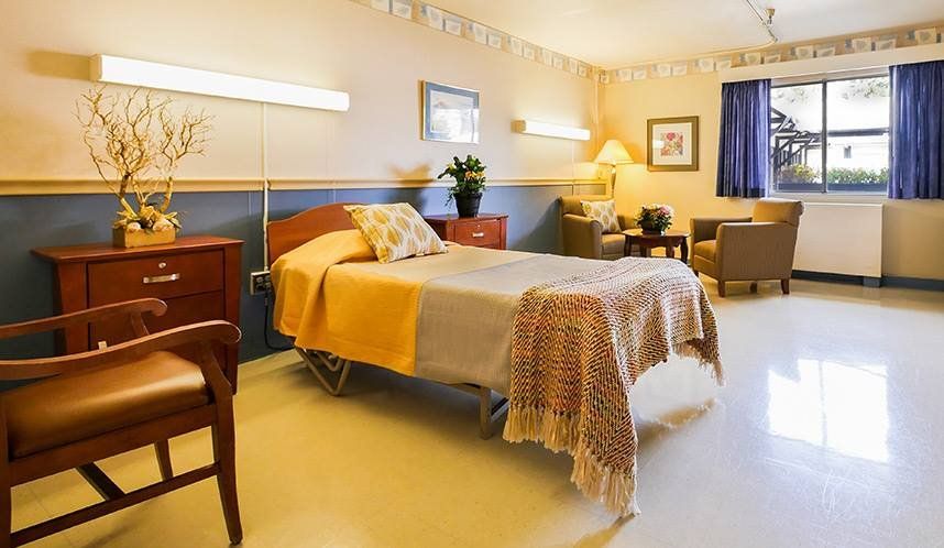 A well-equipped and comfortable hospital room with a single bed and cozy furnishings.