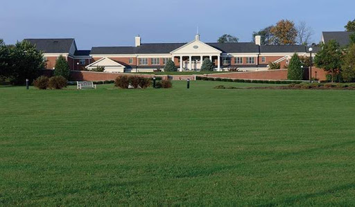A serene view of a grand architectural building set against a lush green landscape.