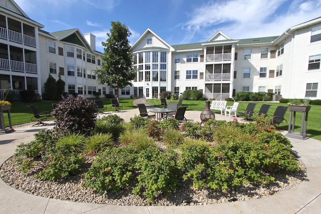 A residential apartment building with well-maintained landscaping and outdoor seating areas.