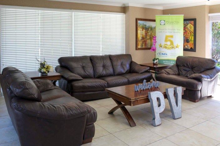 A cozy living room with dark brown sofas and a wooden coffee table.