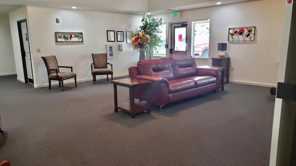 A well-furnished lobby featuring a comfortable sofa, chairs, and decor elements like indoor plants.