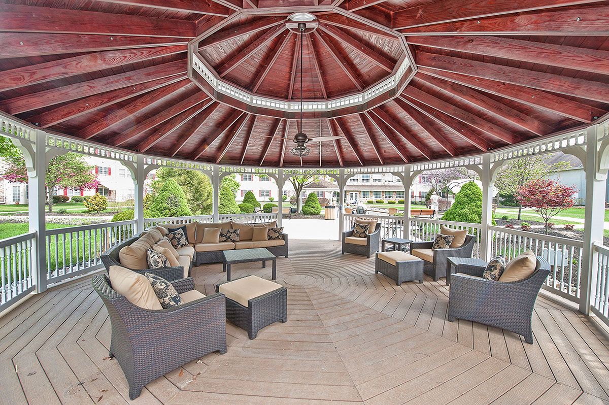 A spacious gazebo with comfortable seating and a garden view.