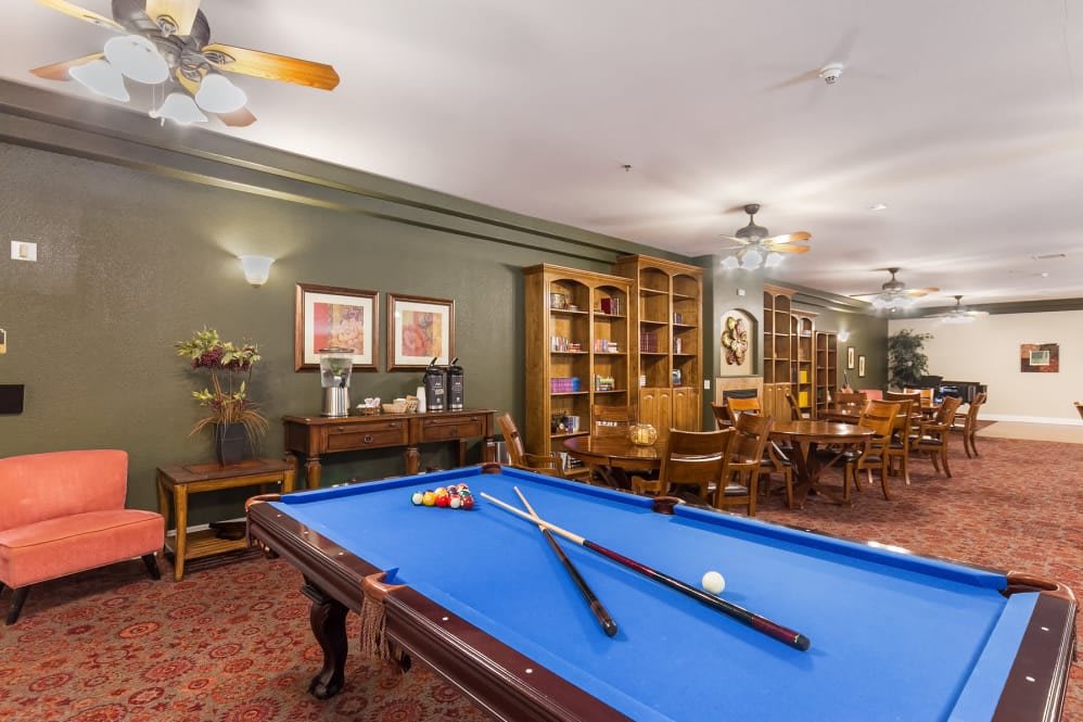 A cozy billiards room with a pool table and surrounding bookshelves, perfect for relaxation and games.