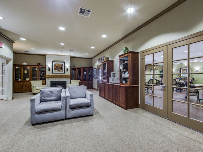 A spacious living room featuring comfortable seating, wooden bookshelves, and a cozy fireplace.
