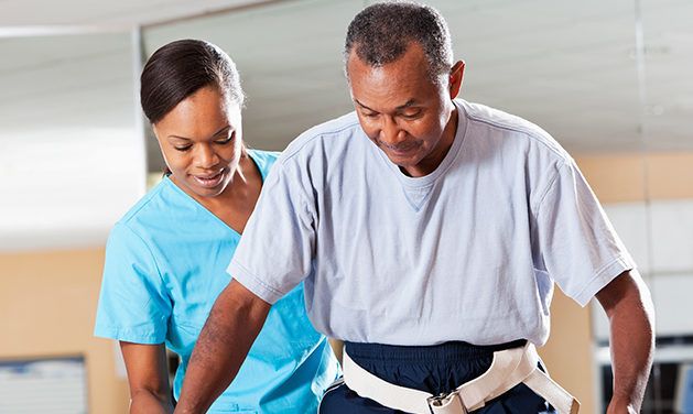 A healthcare professional assists a patient during a physical therapy session.
