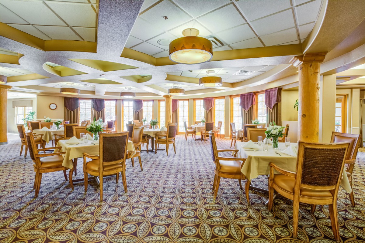 Elegant dining room with well-arranged tables, chairs, and decorative lighting.