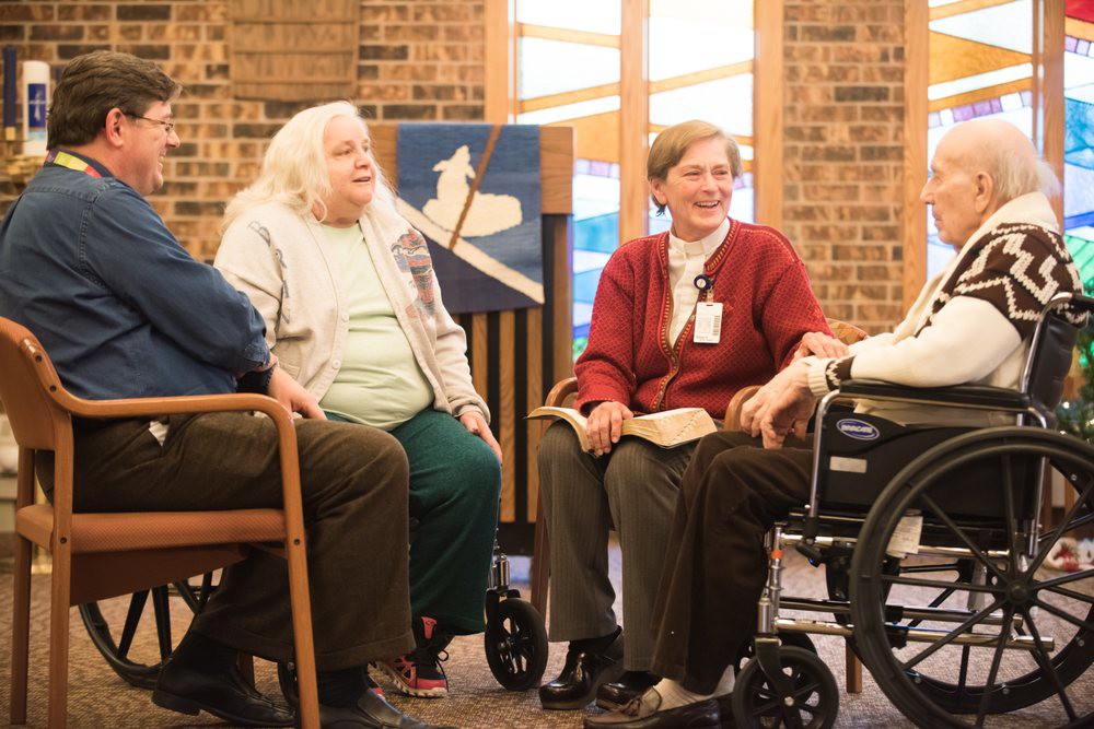 A group of seniors having a discussion in a cozy indoor setting.