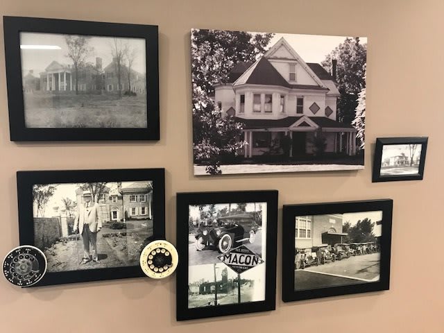 A collection of vintage black-and-white photographs displayed in frames on a wall.