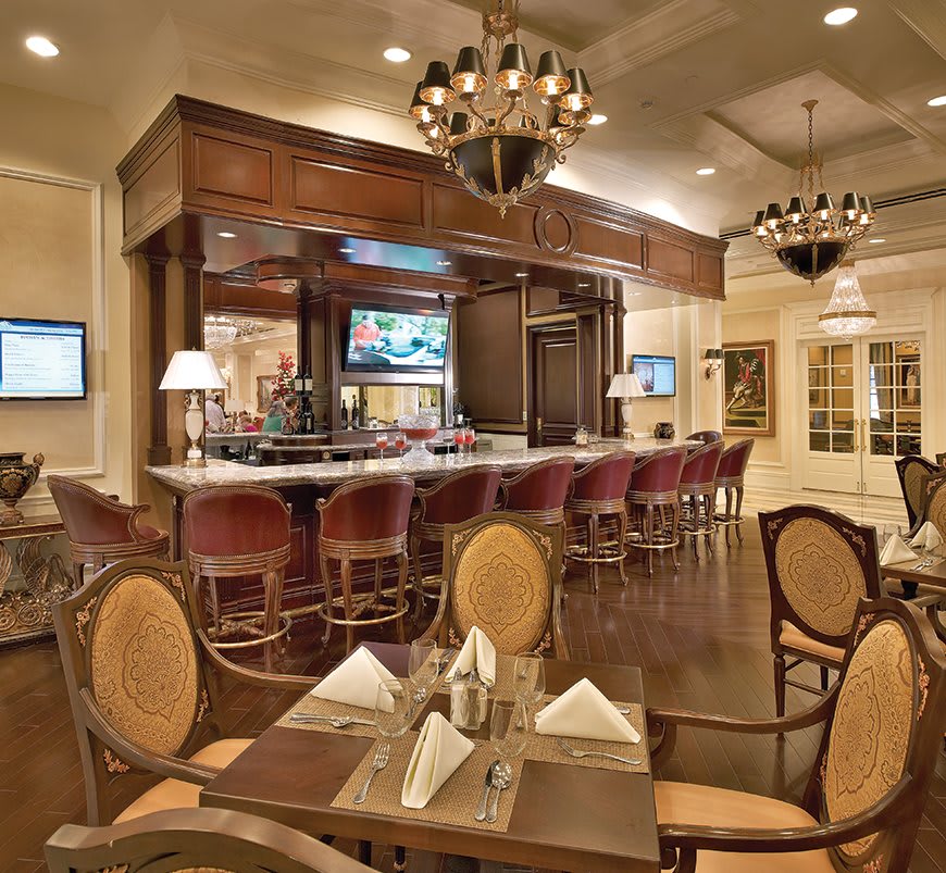 Elegant restaurant interior with a bar and warm lighting.