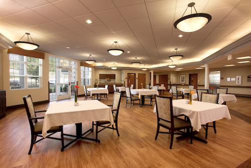 A spacious and elegantly designed dining area featuring neatly arranged tables and ambient lighting.