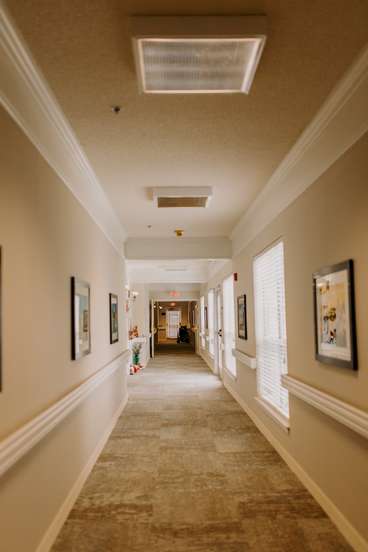 A well-lit hallway adorned with framed pictures on the walls.