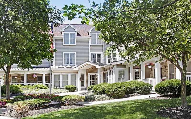 A residential building with well-maintained landscaping on a sunny day.