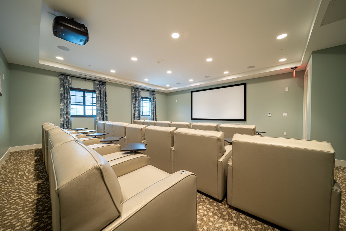 A luxurious home theater with comfortable seating and a large screen.