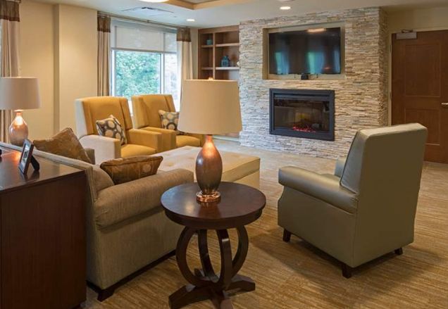 A cozy living room featuring comfortable seating, a fireplace, and a mounted television.