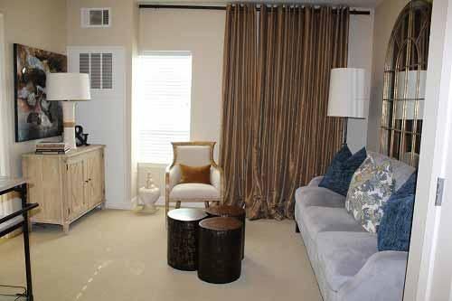 A cozy living room with neutral tones, featuring a sofa, armchair, and stylish decor.