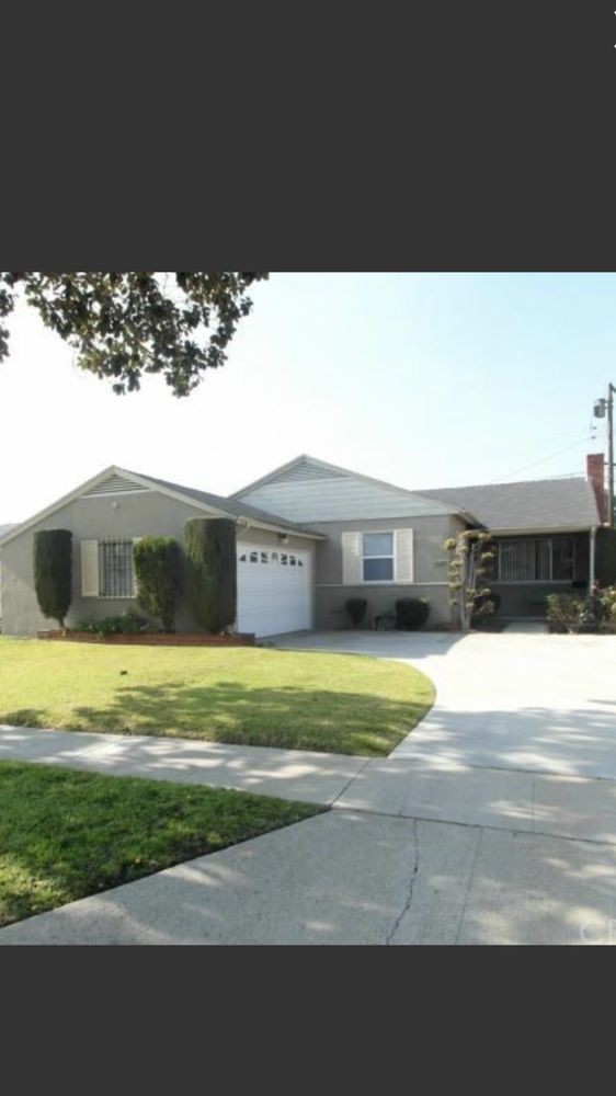 A suburban house with a well-maintained lawn and a driveway leading to a garage.