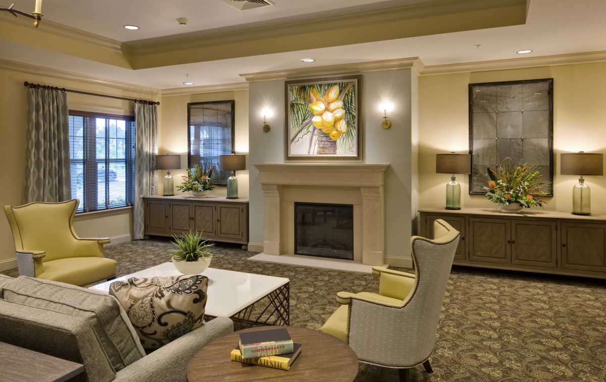A modern and elegantly designed living room featuring a central fireplace, comfortable seating, and tasteful artwork.
