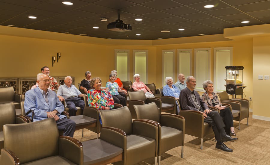 A group of senior citizens seated indoors for a meeting or presentation.