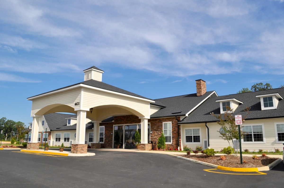 A modern building with an arched entrance under a clear blue sky.