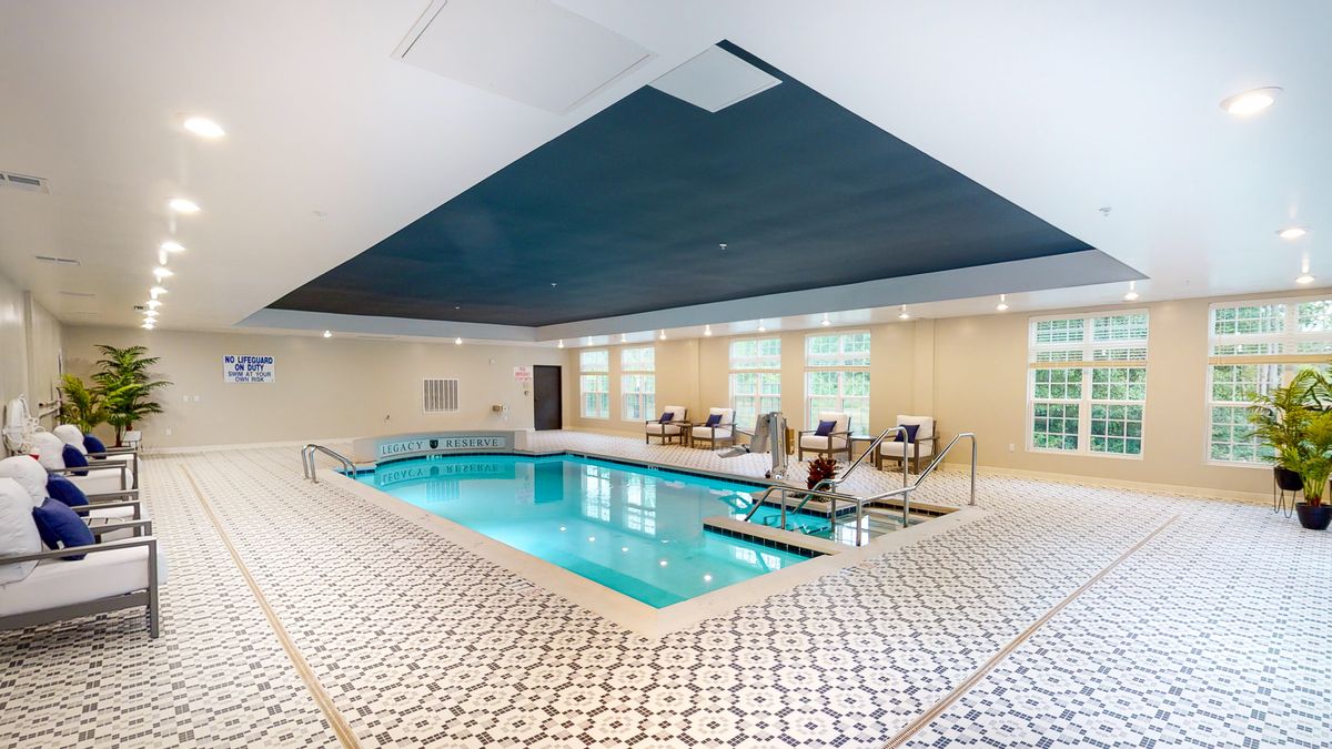 A luxurious indoor swimming pool with modern design and relaxing seating areas.