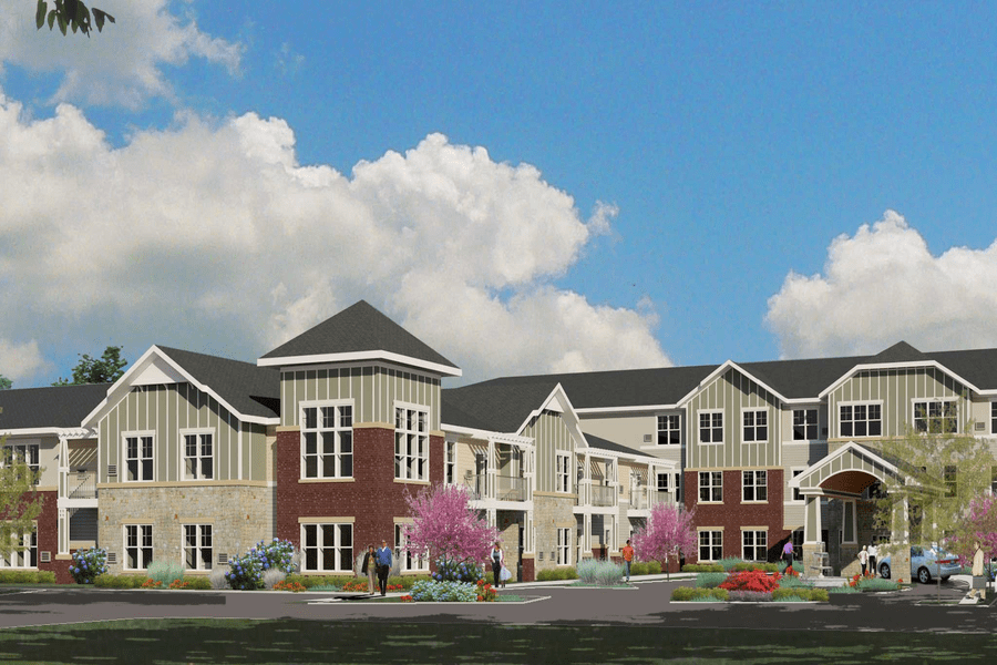 A modern residential building with a landscaped front yard under a partly cloudy sky.