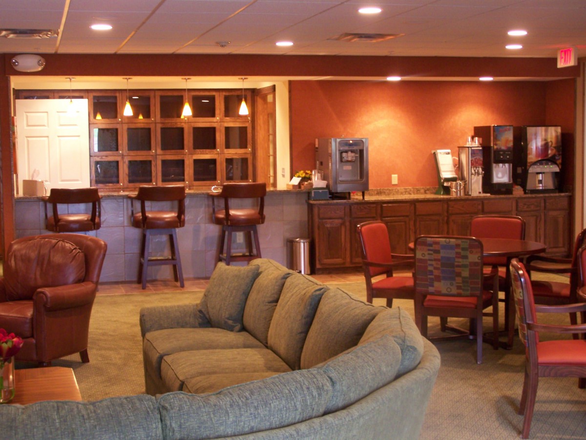 A cozy lounge area with comfortable sofas, chairs, and a bar setup.