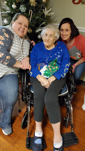 A joyful family moment with an elderly woman in a wheelchair, celebrating together.