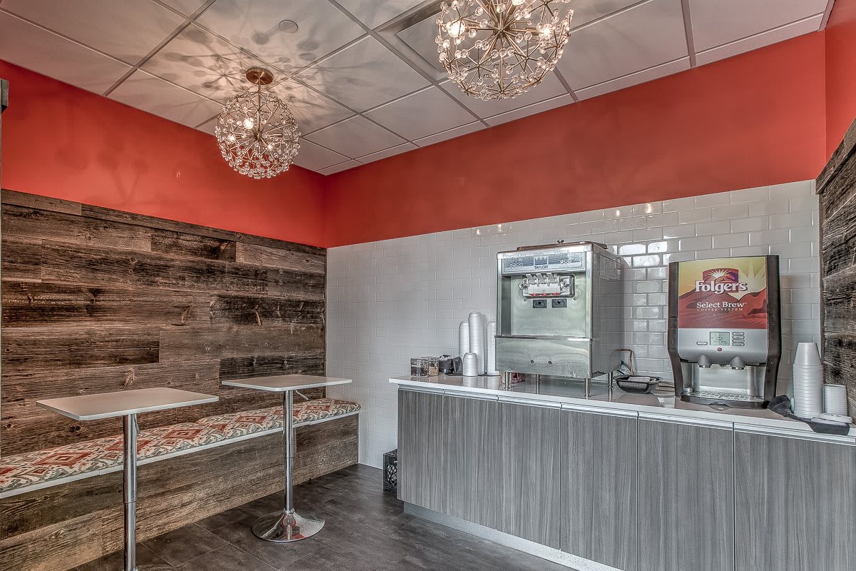 A stylish restaurant interior featuring modern chandeliers and a sleek design with a mix of wood and vibrant colors.