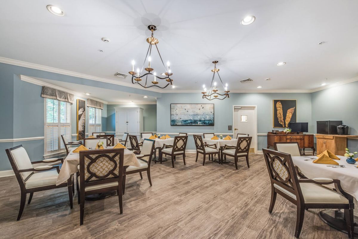 A beautifully designed dining area with elegant chandeliers and neatly arranged tables and chairs.