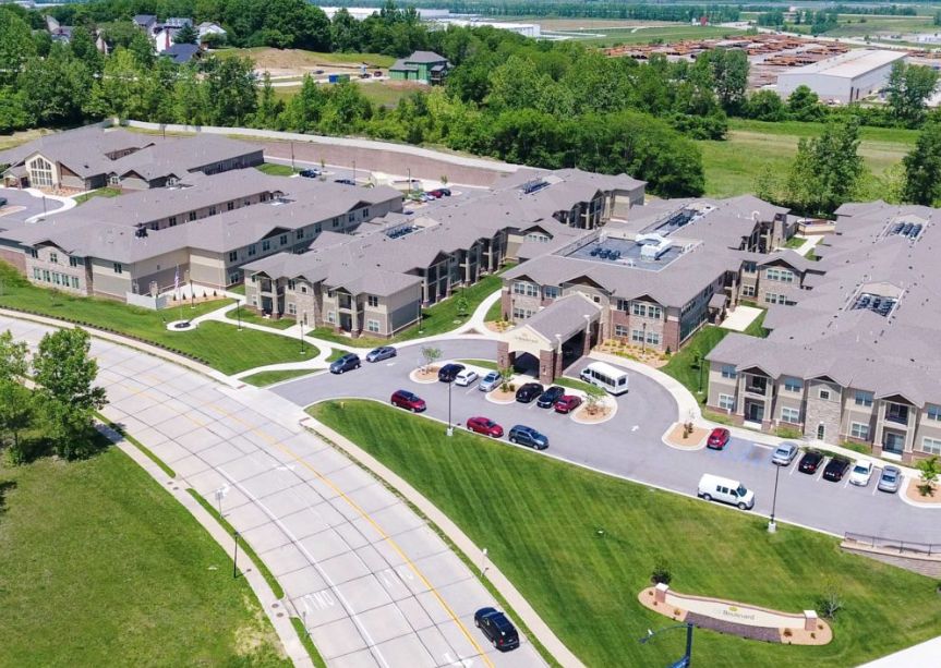 Aerial view of a suburban housing complex with landscaped surroundings.