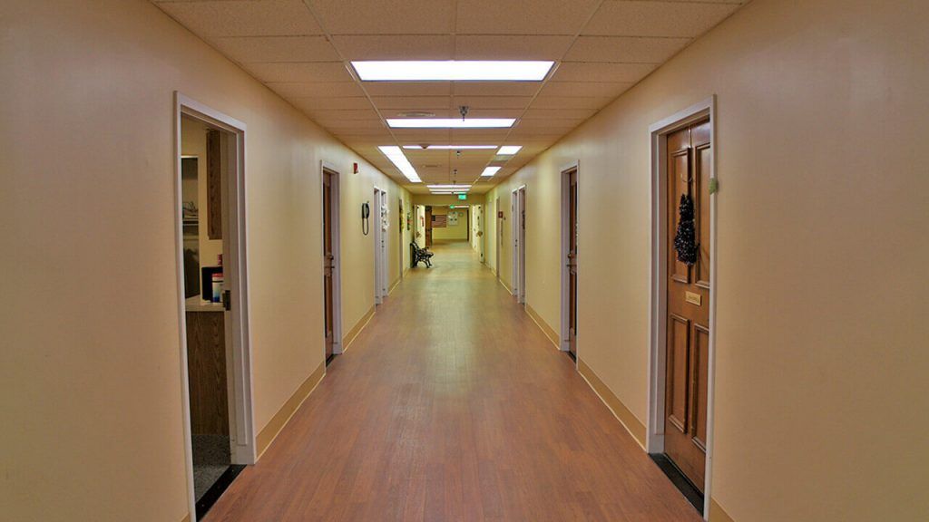 A well-lit indoor hallway with doors on both sides.