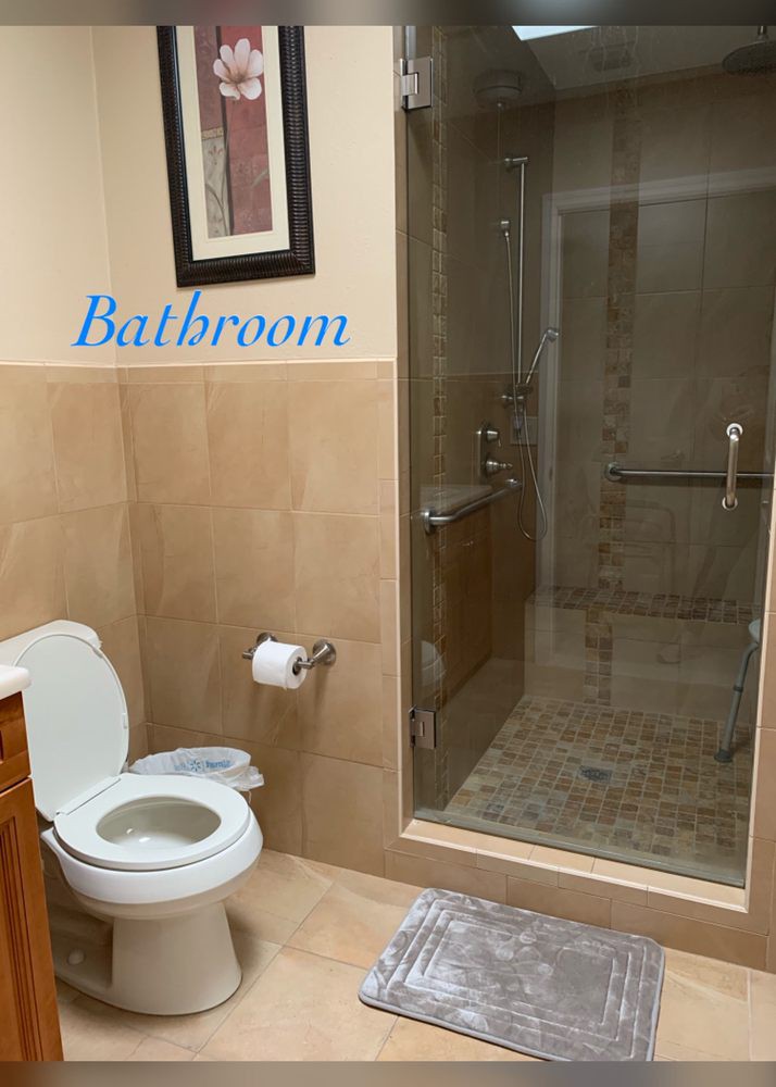 A clean and modern bathroom with a toilet and a glass-enclosed shower.