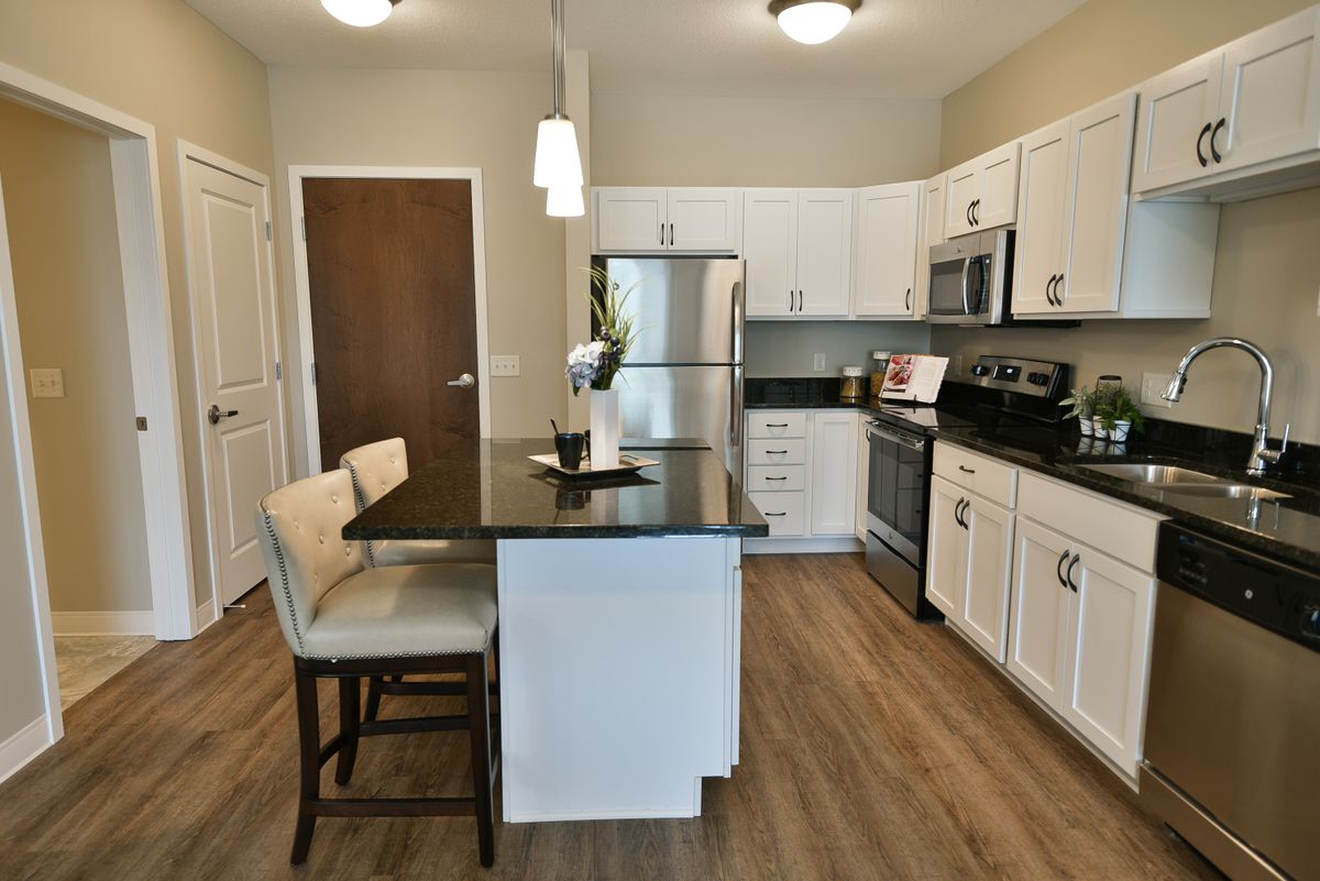 A modern kitchen with white cabinets and stainless steel appliances.