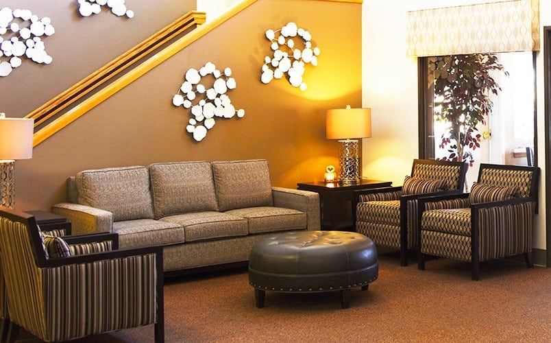 A cozy living room with a modern sofa, armchairs, and stylish decor.