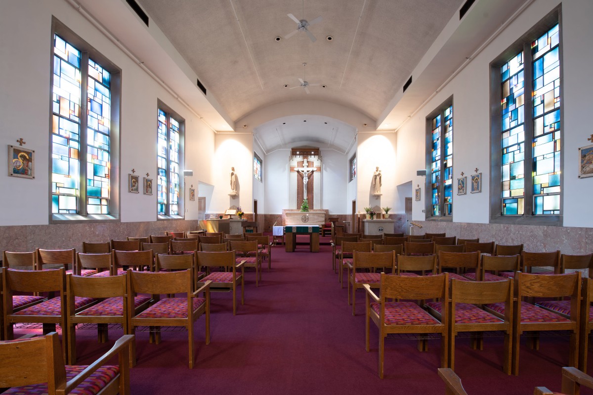 Interior view of a church with wooden pews and an altar at the front.
