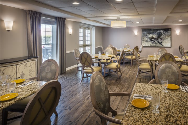 An elegantly designed dining room with neatly arranged tables and chairs.