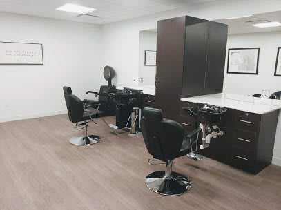 An empty barber shop with several styling chairs and mirrors.