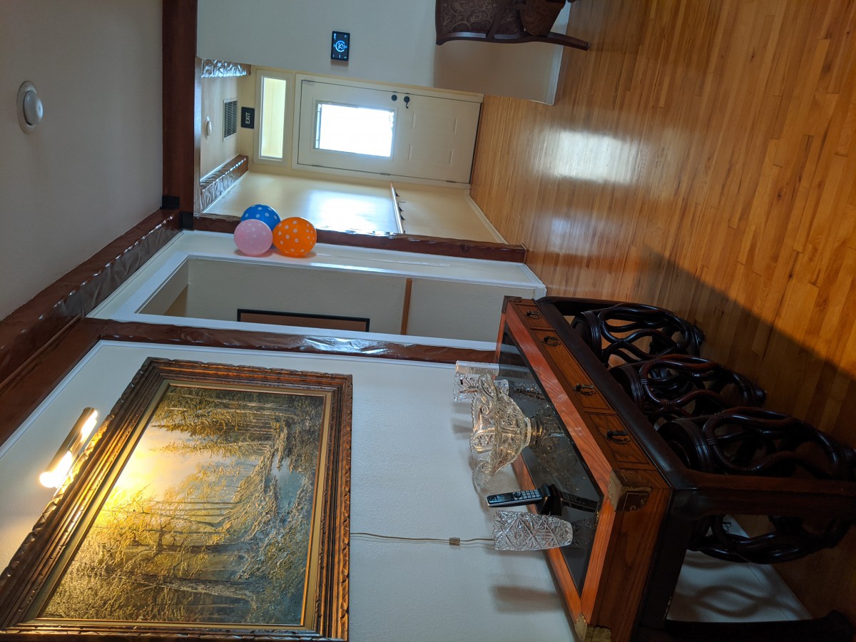 A hallway with balloons, a painting on the wall, and decorative furniture.