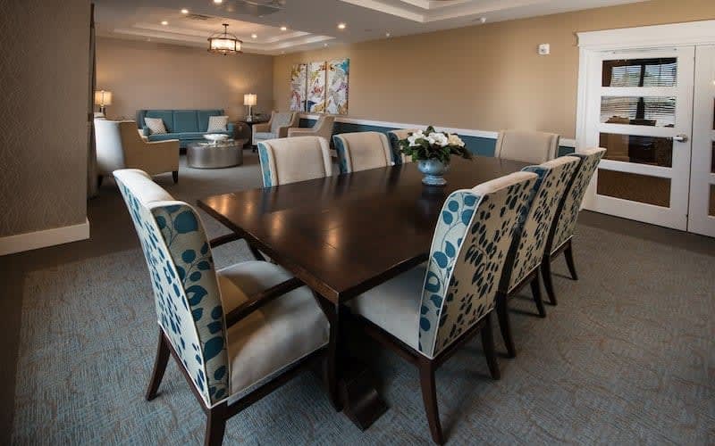 A modern dining room with a large table and patterned chairs, surrounded by elegant interior decor.
