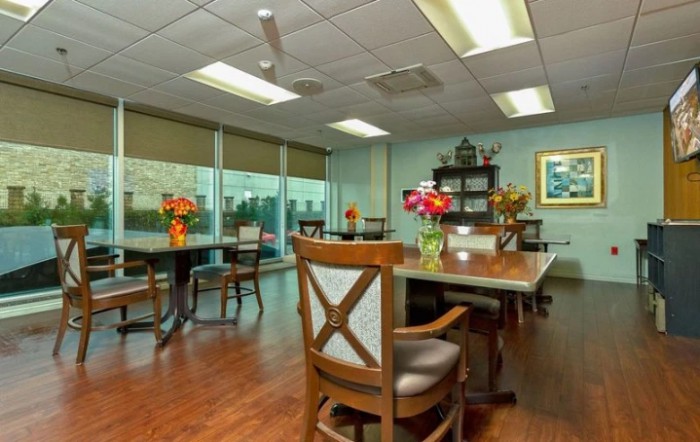 A well-lit conference room with tables, chairs, and decorative flowers.
