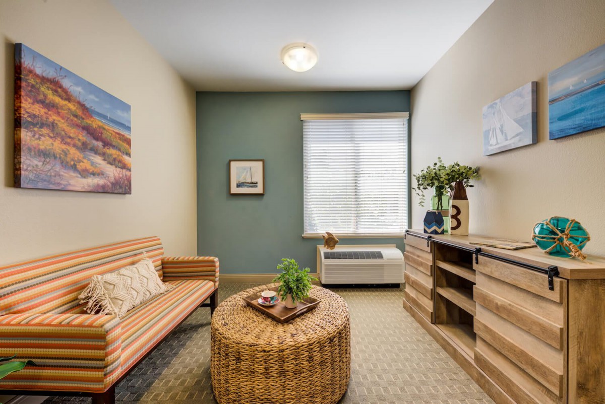 A cozy living room with modern decor, featuring a rattan table, sofa, and natural lighting.