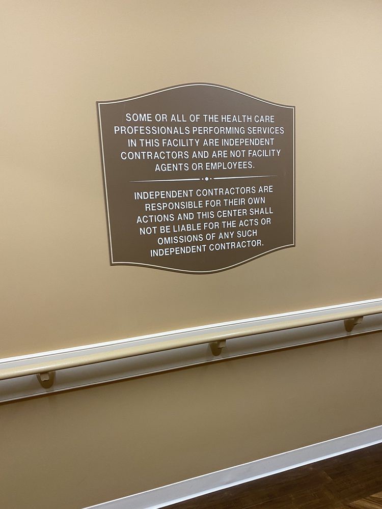 A safety warning sign posted on the hallway wall outlining potential risk and liability disclaimers.