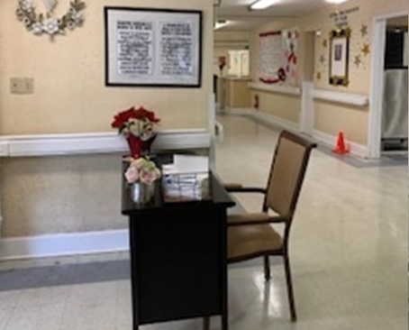 A welcoming waiting area in a healthcare facility, featuring a chair, a small table with flowers, and decorative wall art.