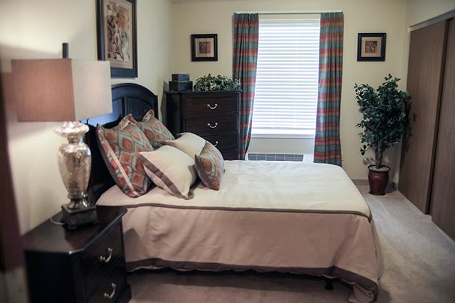 A cozy bedroom with a neatly made bed and stylish decor.