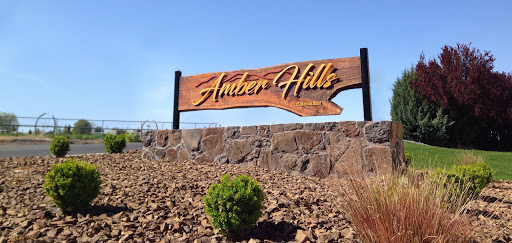 Welcome to Amber Hills: A beautifully crafted wooden sign marking the entrance.