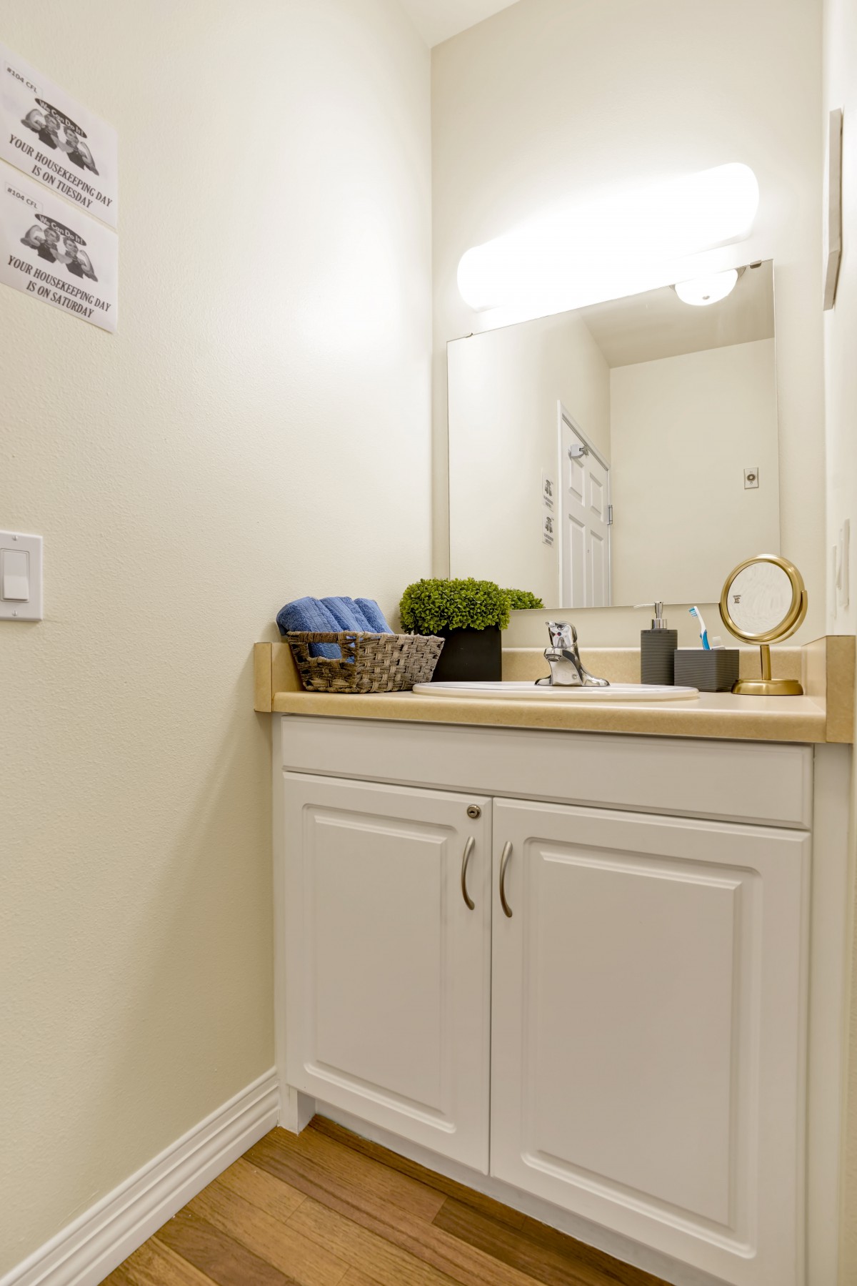 A minimalist bathroom with a sink, cabinet, mirror, and decorative items on the countertop.