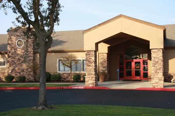 A building entrance with a paved pathway and surrounding greenery.