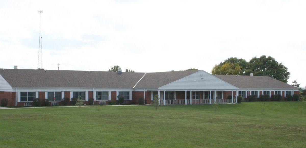 A single-story residential building with a large lawn in front.