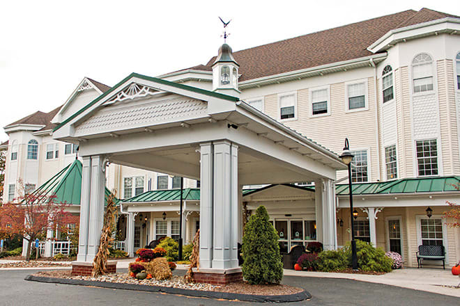 Entrance of a classic-style hotel with columns and landscaping.