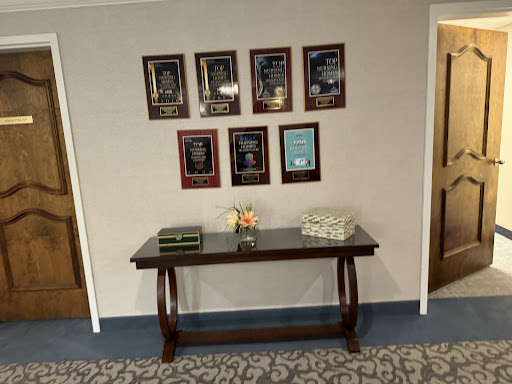 A well-decorated wall showcasing awards and a table with floral arrangements.